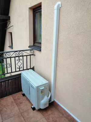 Jednostka zewnętrzna klimatyzacji umieszczona na balkonie domku jednorodzinnego