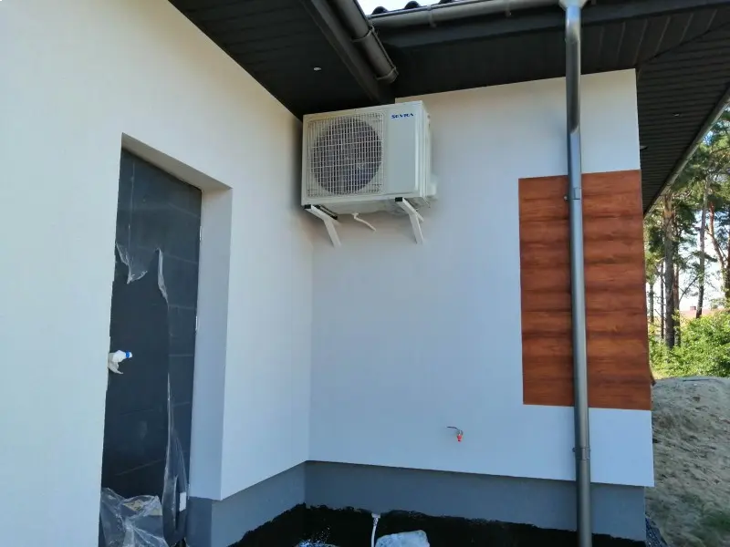 Klimatyzator zewnętrzny umieszczony w zacienionym miejscu na elewacji budynku